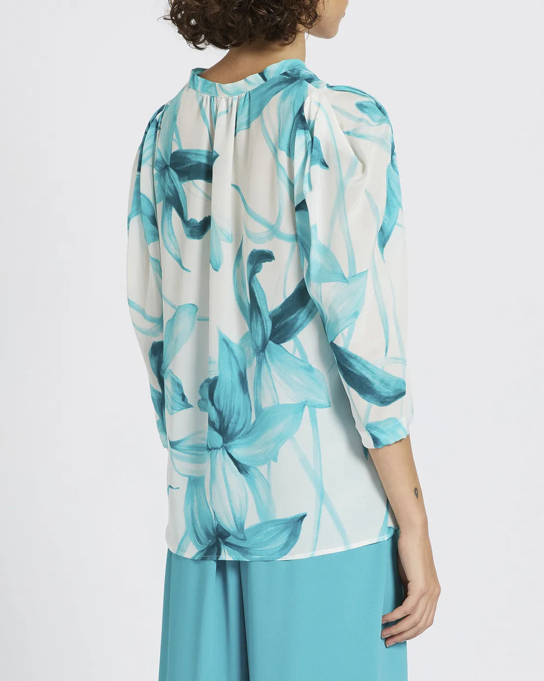 Blusa bianca in crêpe di seta a fantasia fiori tropicali smeraldo con maniche tre quarti e arricciatura sulle spalle